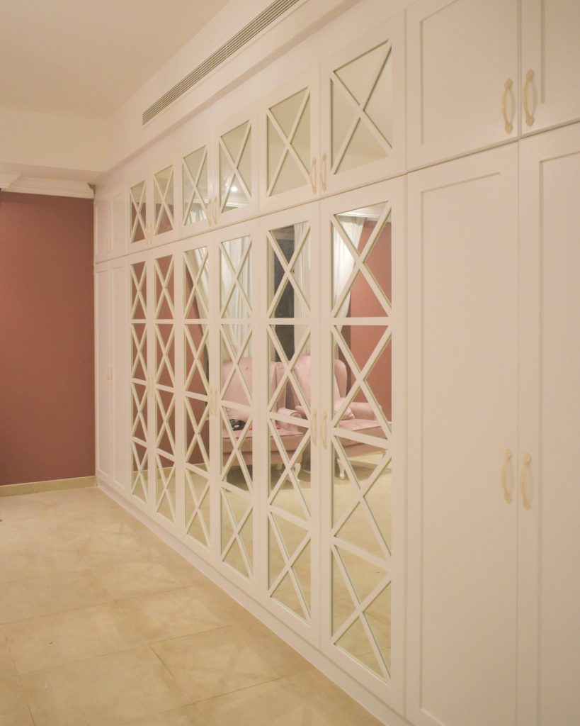 Wood works Dubai: fitted wardrobes with mirrored geometric doors and brass handles in a villa