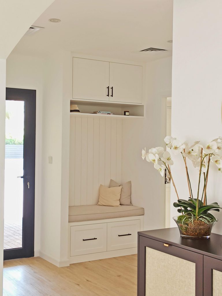 Fitted hallway bench with tongue-and-groove backing, an upholstered seat and storage drawers below